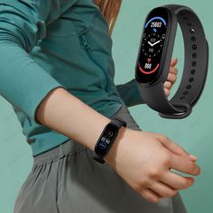 a woman holding onto a smart watch in her left hand and showing the time on it