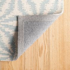 a blue and white rug on top of a wooden floor next to a wood floor