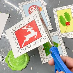 someone is cutting out christmas stamps with scissors