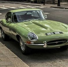 a green sports car is parked on the side of the road