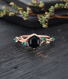 an image of a black diamond ring on a wooden table with greenery in the background