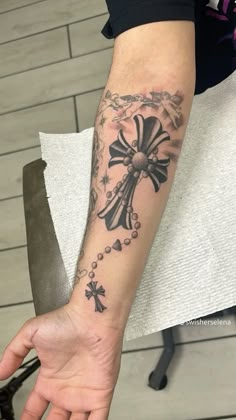 a person with a cross tattoo on their arm