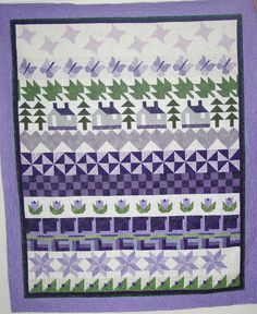 a purple and green quilt with trees on it's side, in the middle