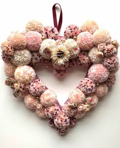 a heart shaped decoration made out of pink and white balls