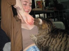 a woman petting a cat on the nose