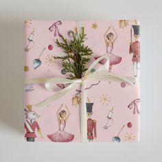 a present wrapped in pink wrapping paper with nutcrackers and dancers on it