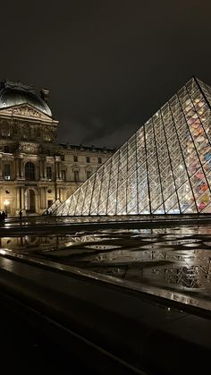 the large glass pyramid is lit up at night