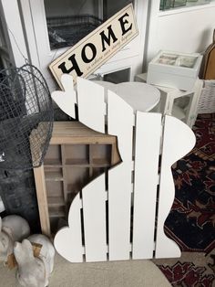 a white wooden fence with a sign that says home on it next to other items