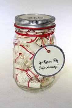 a mason jar filled with lots of white and red string wrapped around the lid that says, 40 reasons why you're amazing