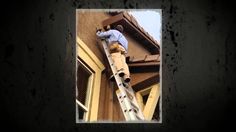 a man climbing up the side of a building with a ladder on it's side