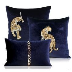 three pillows with gold leopards on them, one in blue and the other in black