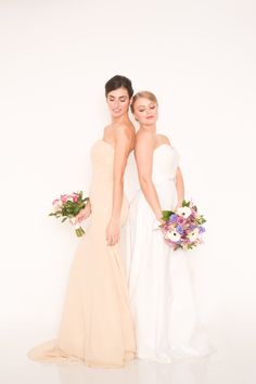 two bridesmaids pose for a photo in their wedding gowns