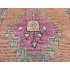 a pink and blue rug with an ornate design