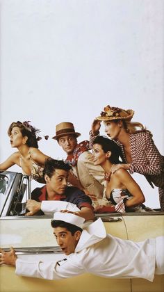 a group of people sitting in the back of a car with one person leaning on the roof