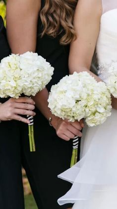 the bridesmaids are holding their bouquets with white flowers in each one's hands