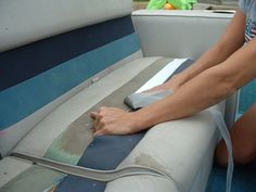 a woman is cleaning up the mattress on her boat's back end with a brush