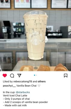 a starbucks cup sitting on top of a counter next to donuts