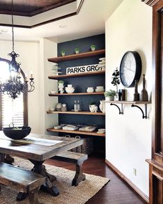 a dining room table and benches in front of shelves