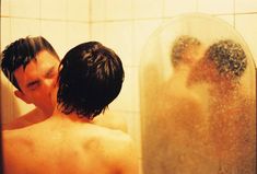 two young men are kissing in the shower