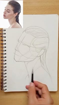 someone is drawing a woman's head with a pencil on a piece of paper