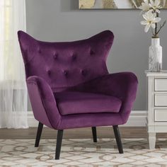 a purple chair sitting on top of a white rug