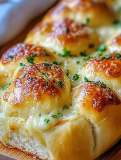 a cheesy bread with cheese and herbs on it sitting on a cutting board