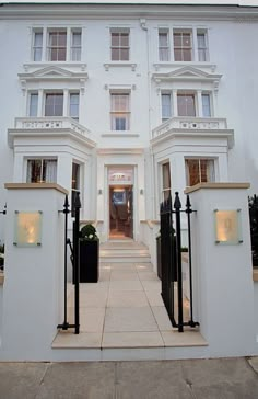 a large white building with many windows and black gated entry way leading into it