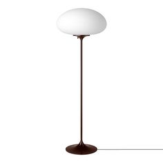 a lamp that is on top of a white flooring area with a brown base