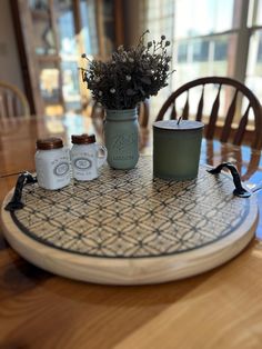 the table is set with jars and flowers on it, along with other items for decor