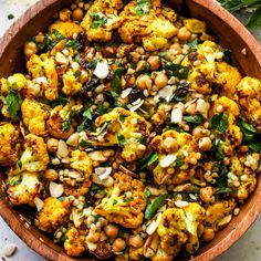 a wooden bowl filled with cauliflower and chickpeas