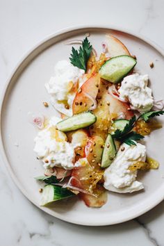 a white plate topped with cucumber and other food