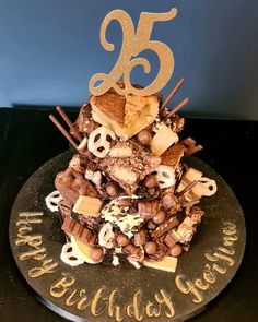 a birthday cake with chocolate, marshmallows and cookies on top that says 25