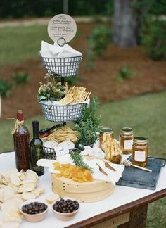 a table topped with lots of food and condiments next to a forest filled field