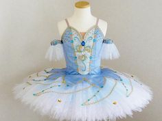 a blue and white ballerina dress sitting on top of a mannequin