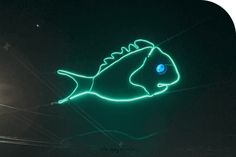 a neon fish sign hanging off the side of a building in front of a street light