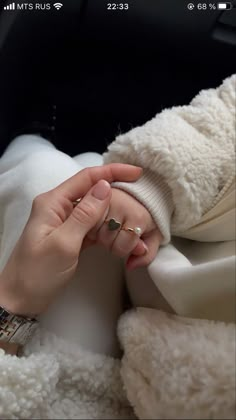 a woman is holding the hand of another person who is wearing a white coat and gold ring