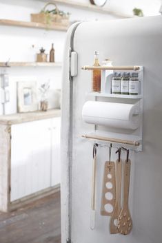 a white refrigerator freezer sitting in a kitchen next to wooden utensils and spoons