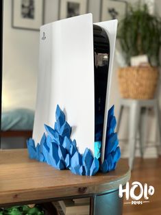 an open laptop computer sitting on top of a wooden table next to a blue flower