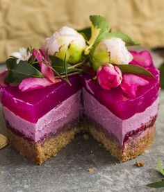 there is a piece of cake with purple icing and flowers on the top slice