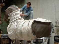 a man is working on a horse statue