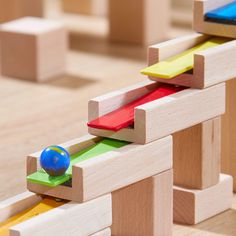 a wooden toy with colorful blocks and a ball