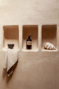 three niches in the wall with towels and soap