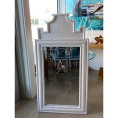 a large white mirror sitting on top of a tiled floor