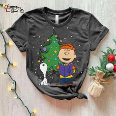 a charlie brown christmas tree shirt on a wooden table next to some ornaments and decorations