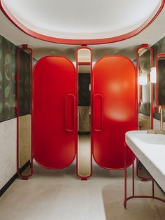 the bathroom is decorated in red and white with an oval mirror above the door that opens up to another room