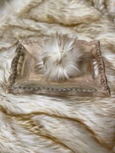 a furry white fur rug with a metal tray on it