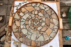 a circular stone mosaic sitting on top of a wooden pallet