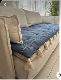 a couch with tassels and pillows on it