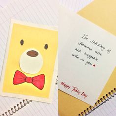 a yellow bear with a red bow tie next to a note