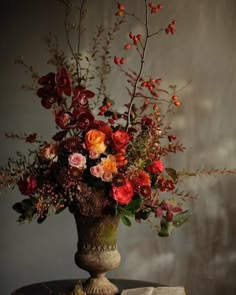 a vase filled with lots of flowers sitting on top of a table next to a book